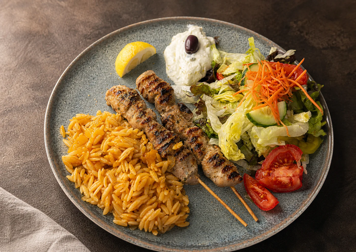 Souvlaki mit griechischen Reisnudeln, Salat und Tzatziki
